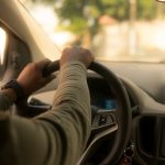 Un conducteur tient le volant à l'intérieur d'une voiture en conduisant