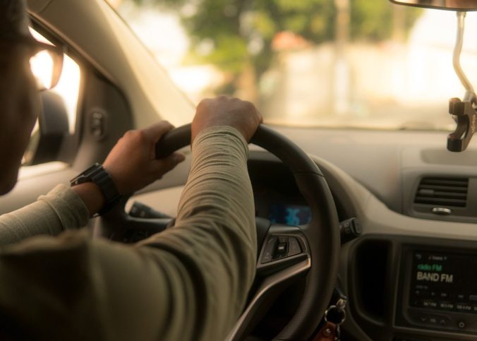 Un conducteur tient le volant à l'intérieur d'une voiture en conduisant