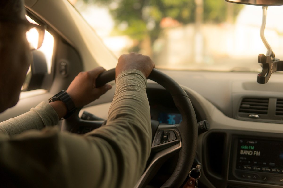 Un conducteur tient le volant à l'intérieur d'une voiture en conduisant