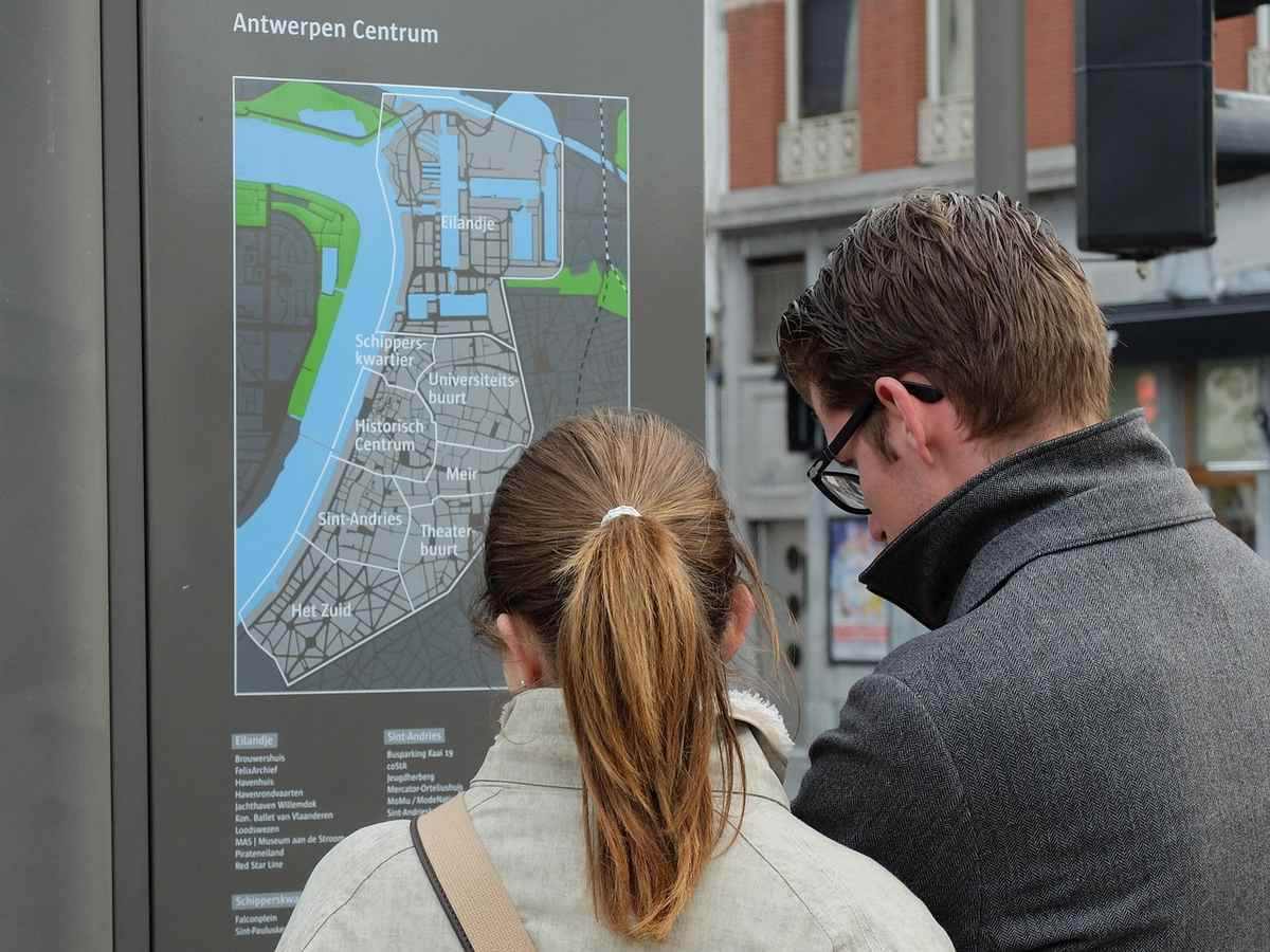 Couple examine un plan du centre urbain pour s'orienter Couple examine un plan du centre urbain pour s'orienter